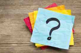 question mark on a sticky note against grained wood
